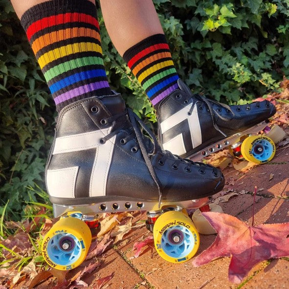 person wearing black mid calf socks with rainbow stripes and rollerskates 